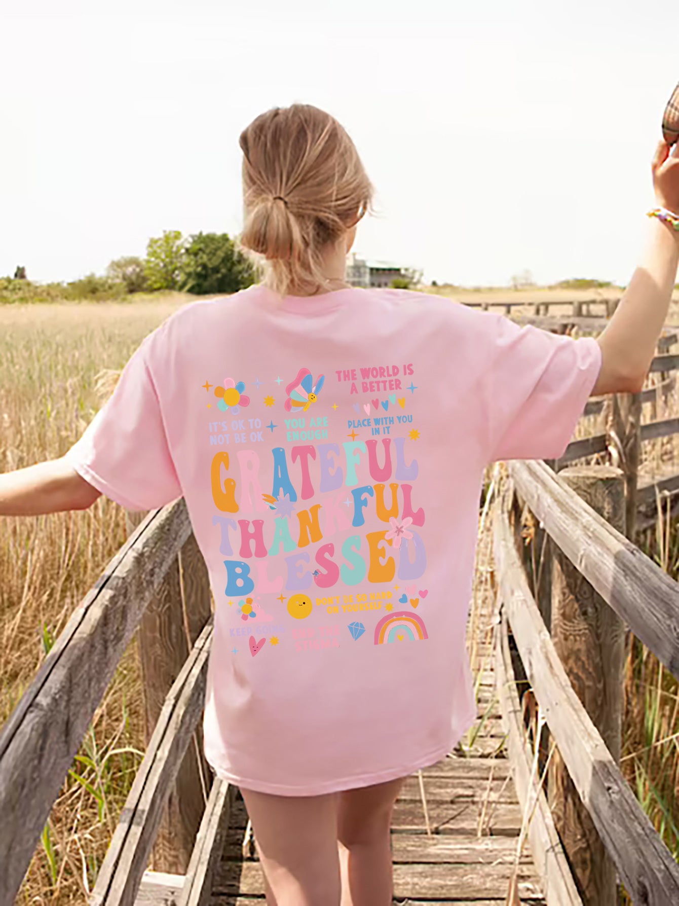 Pink T-shirt with colorful gratitude graphic on back