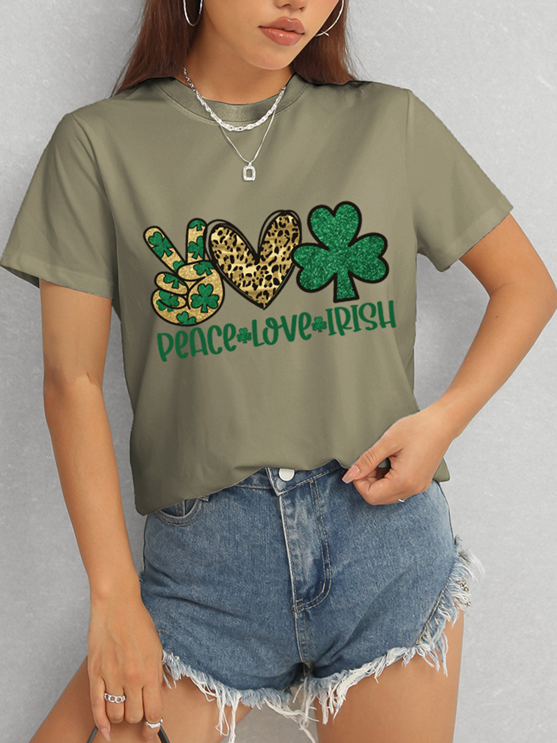 Model in olive Peace Love Irish T-Shirt and denim shorts