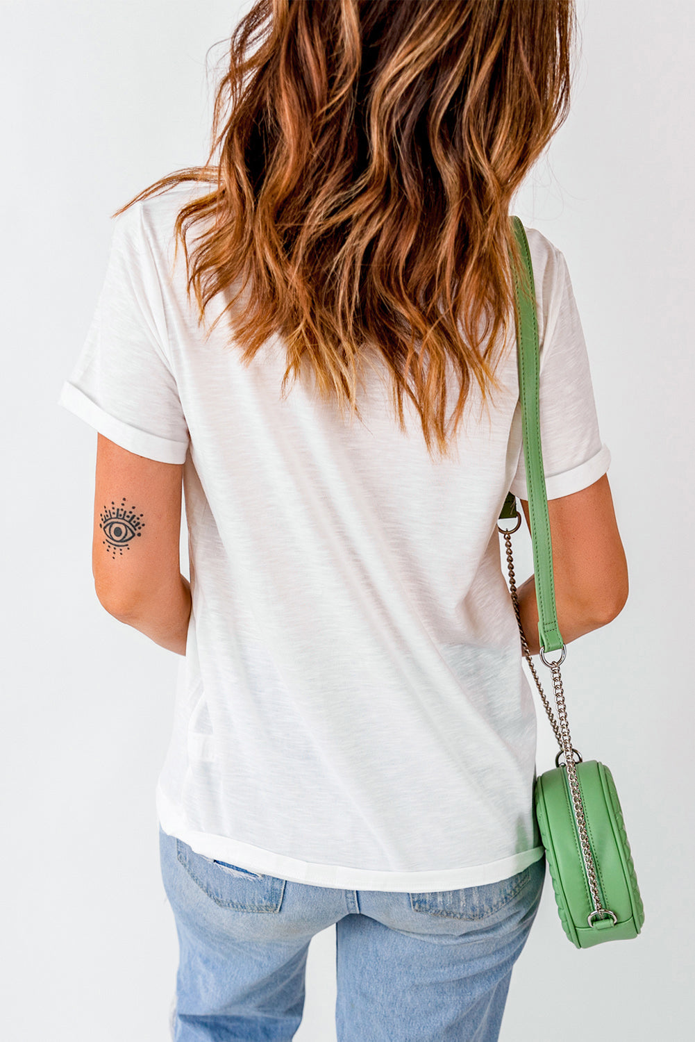Back view of white graphic T-shirt with rolled sleeves