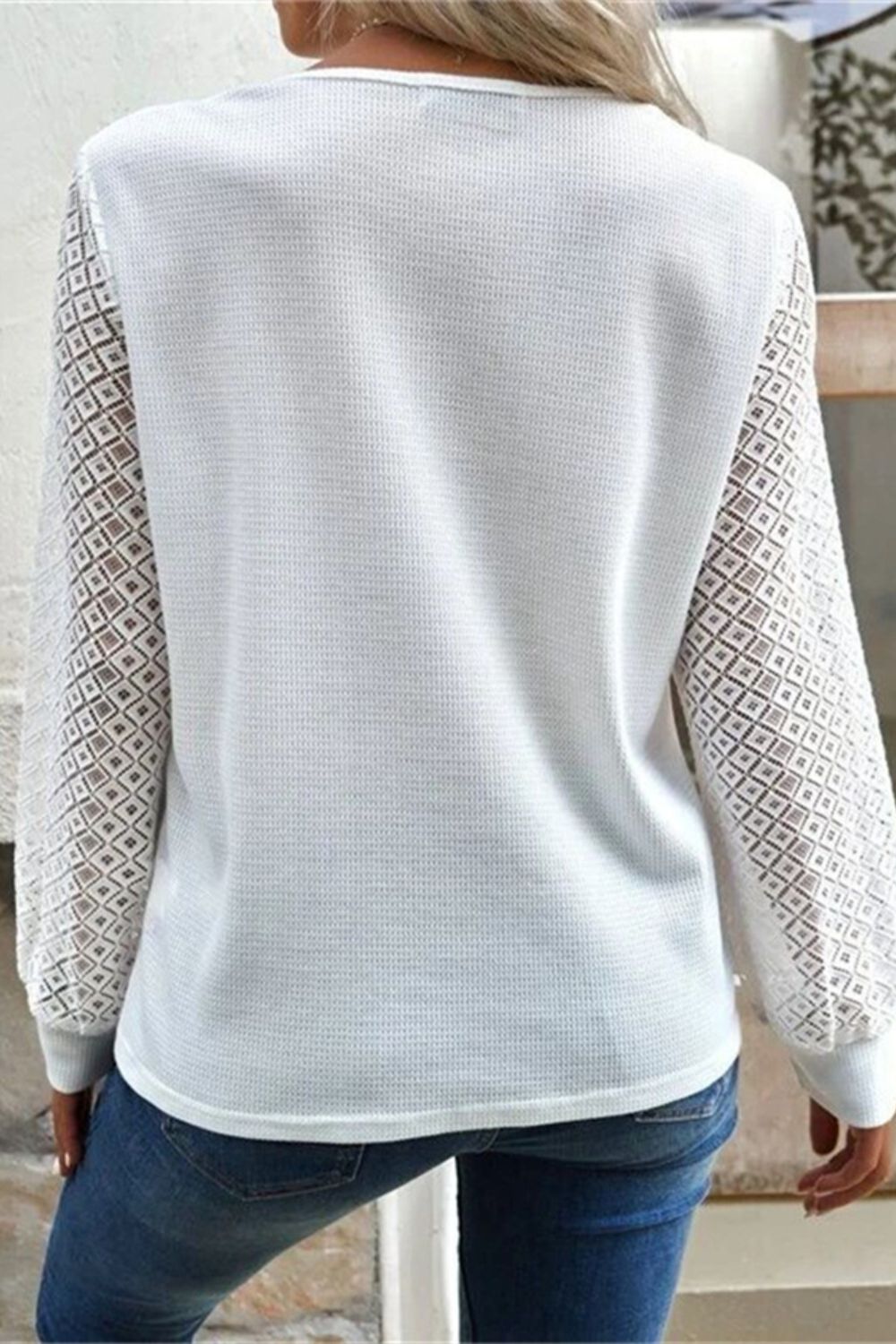 Back view of white V-neck t-shirt with lace sleeves.