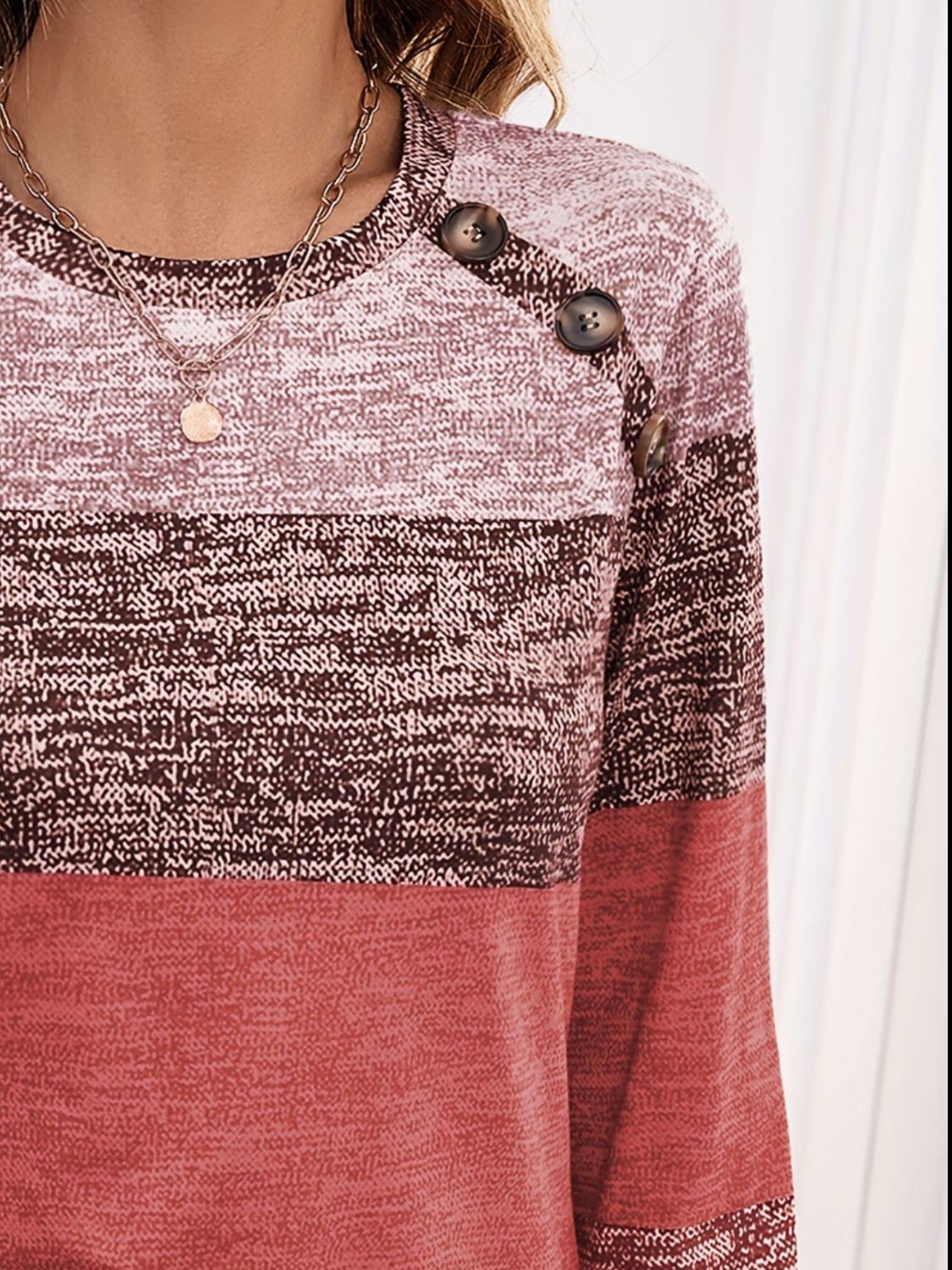 Close-up of red decorative button contrast round neck T-shirt.