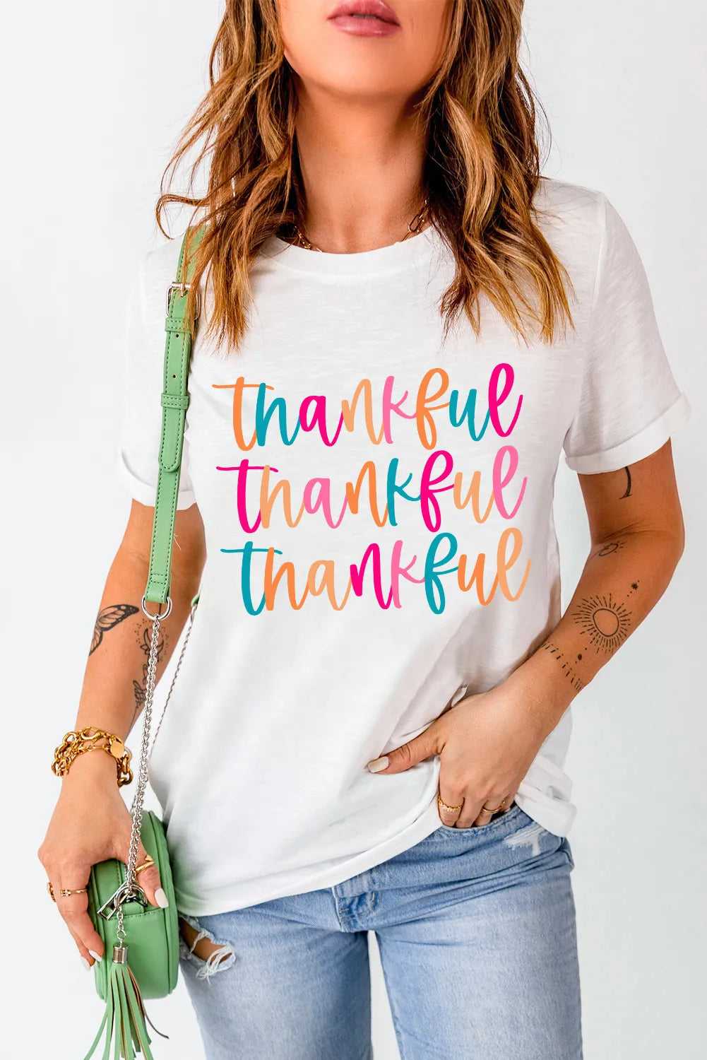 Model wearing THANKFUL T-shirt with colorful text, round neck.