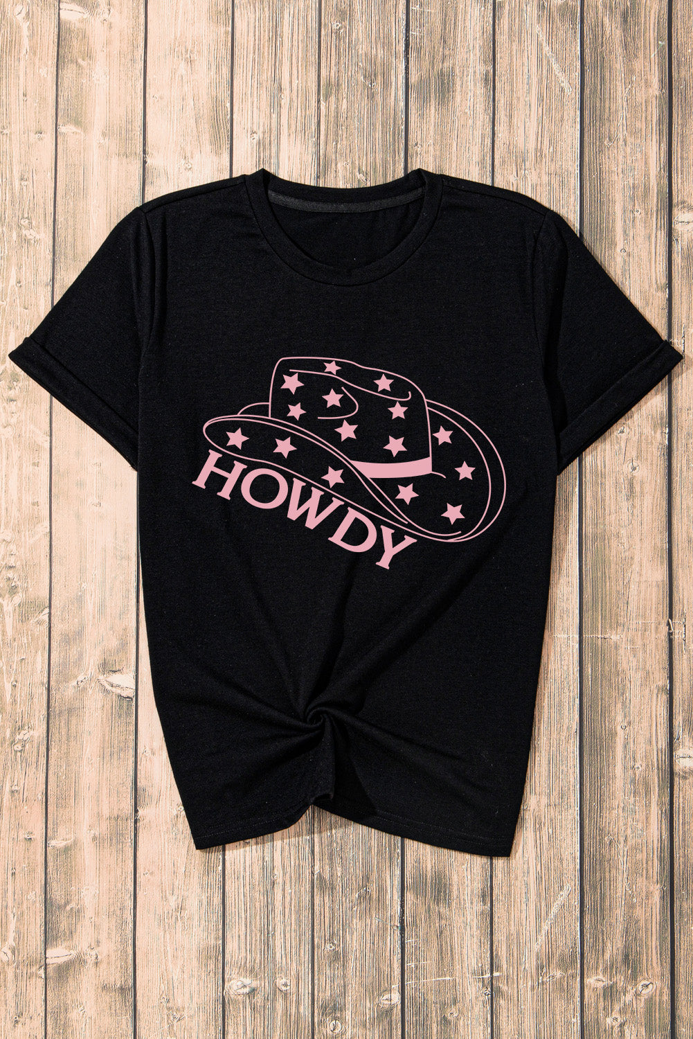 Flat lay of HOWDY t-shirt with pink cowboy hat graphic