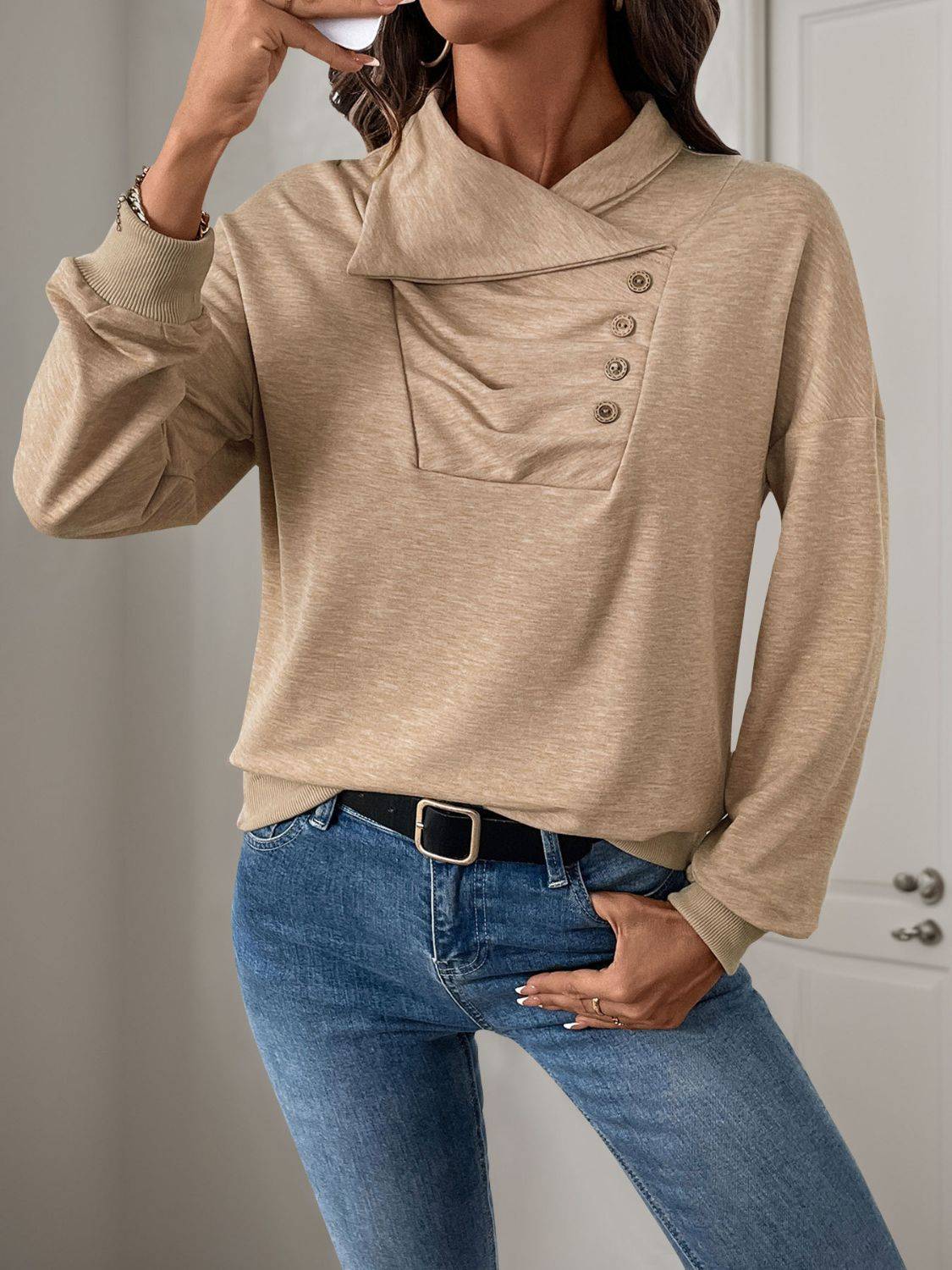 Model wearing beige asymmetric mock neck sweatshirt.