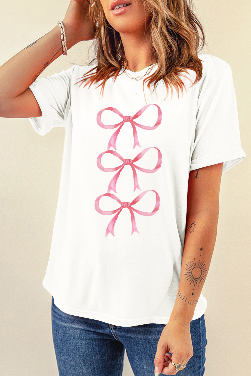 White T-shirt with pink bow graphic, round neck, short sleeves.