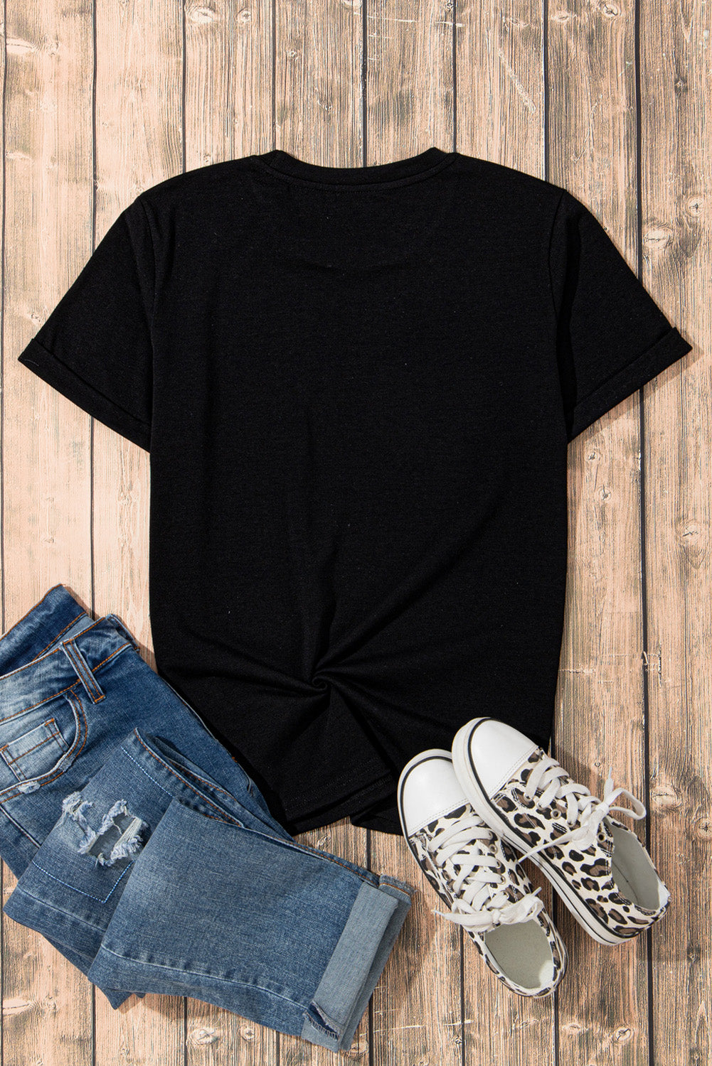 Back view of black graphic t-shirt with jeans and sneakers