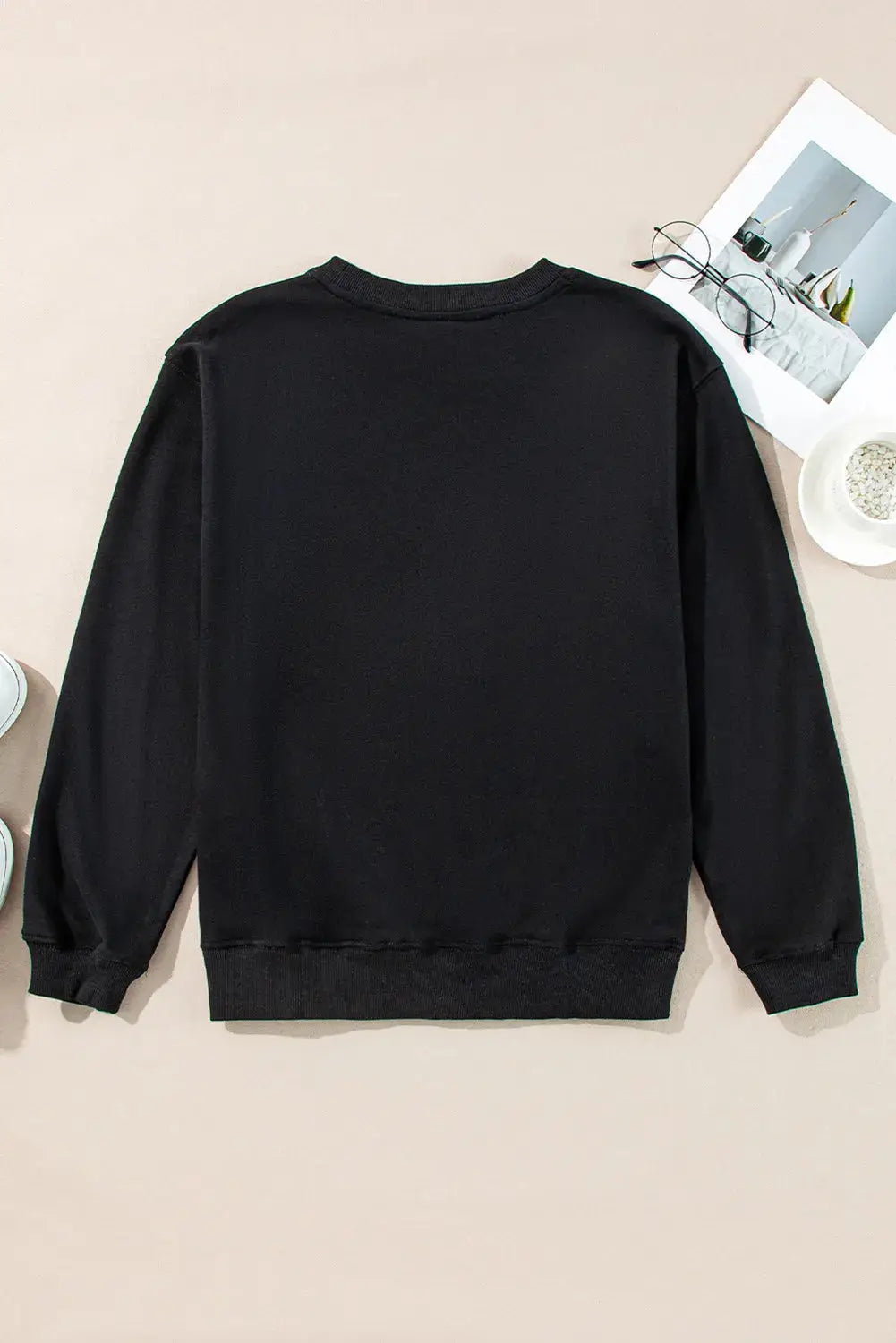 Flat lay of back view of black long sleeve sweatshirt