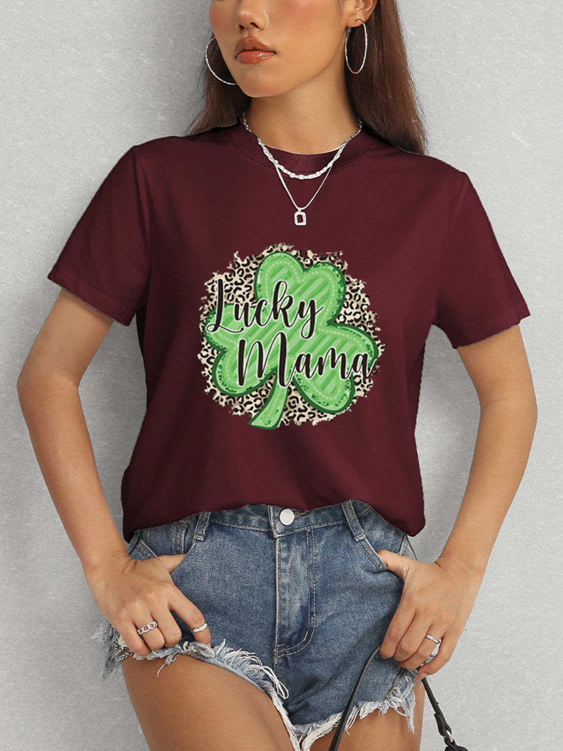 Model in burgundy Lucky Mama t-shirt and denim shorts