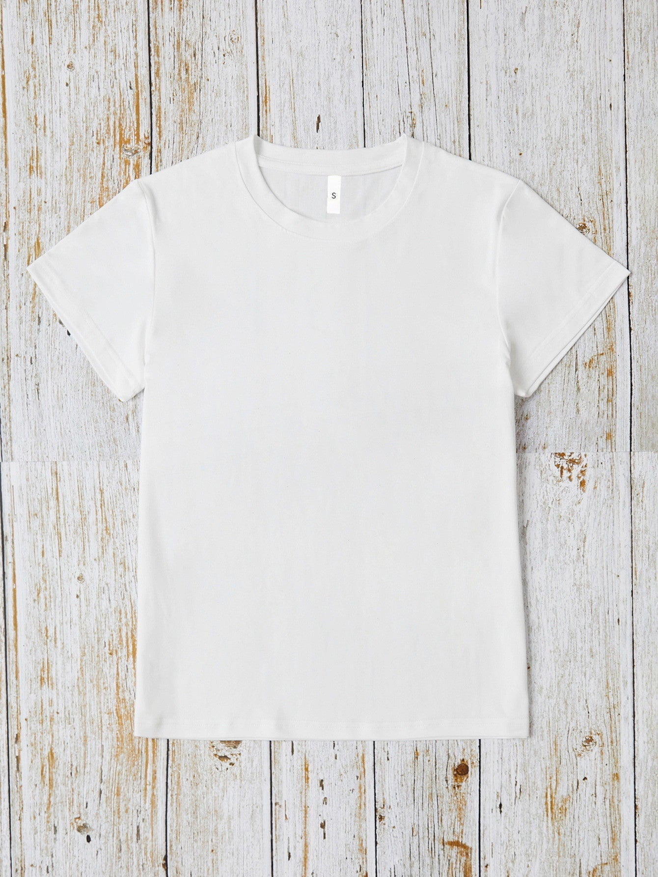 Plain white round neck T-shirt on wooden background
