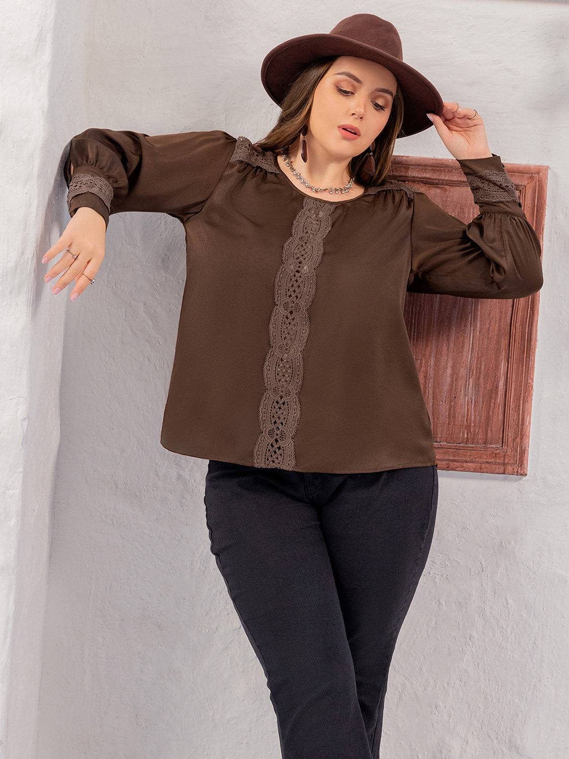 Model wearing plus size lace detail blouse, relaxed pose.