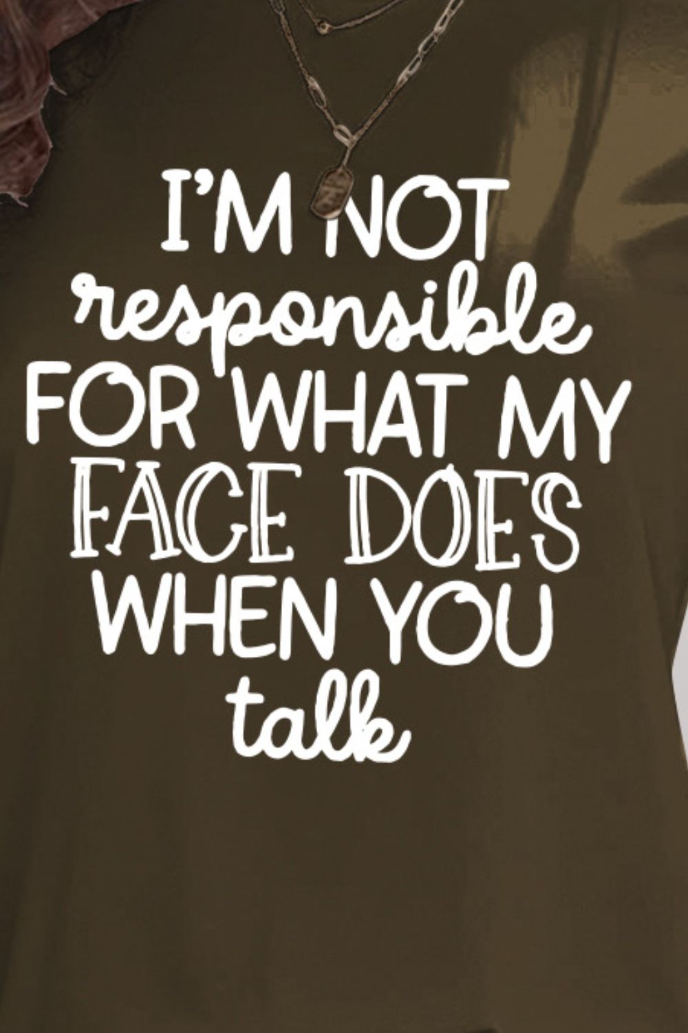 Close-up of letter graphic on olive green T-shirt