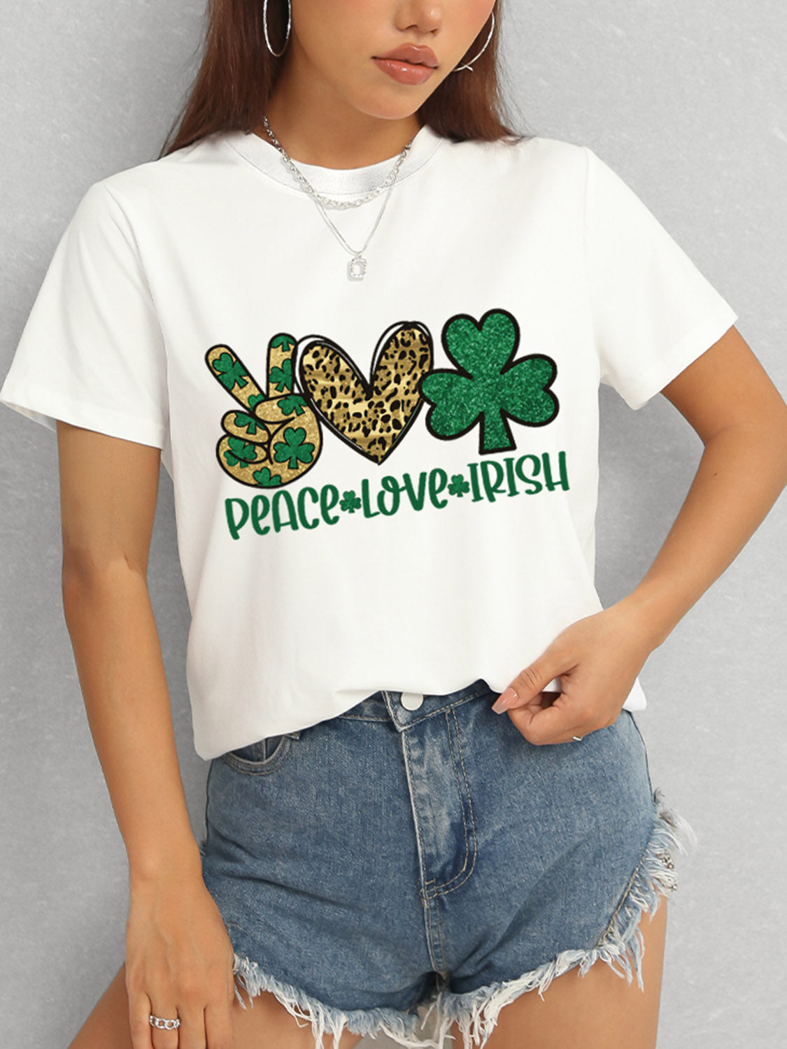 Model in white Peace Love Irish T-Shirt and denim shorts