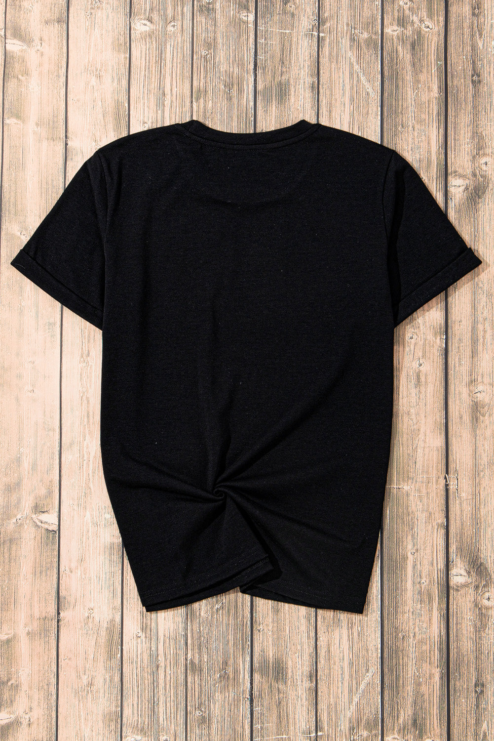 Back view of black T-shirt on wooden background.