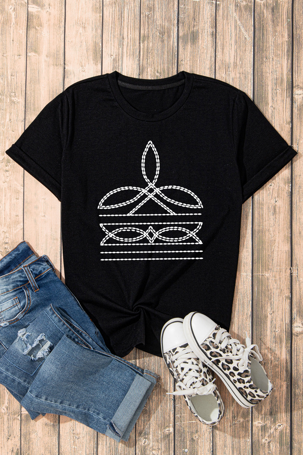 Flat lay of black graphic t-shirt with jeans and sneakers