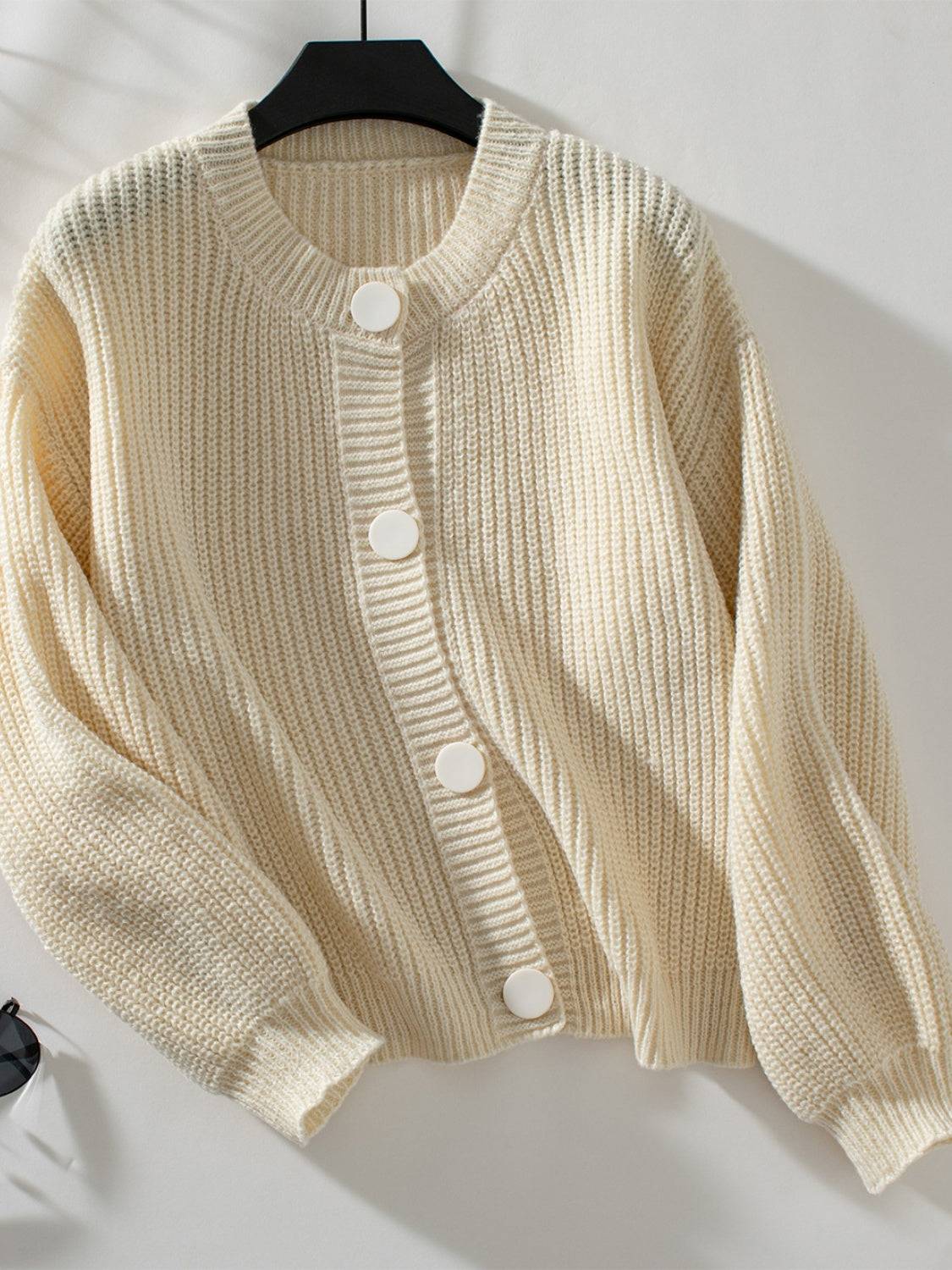 Cream button down long sleeve cardigan on hanger