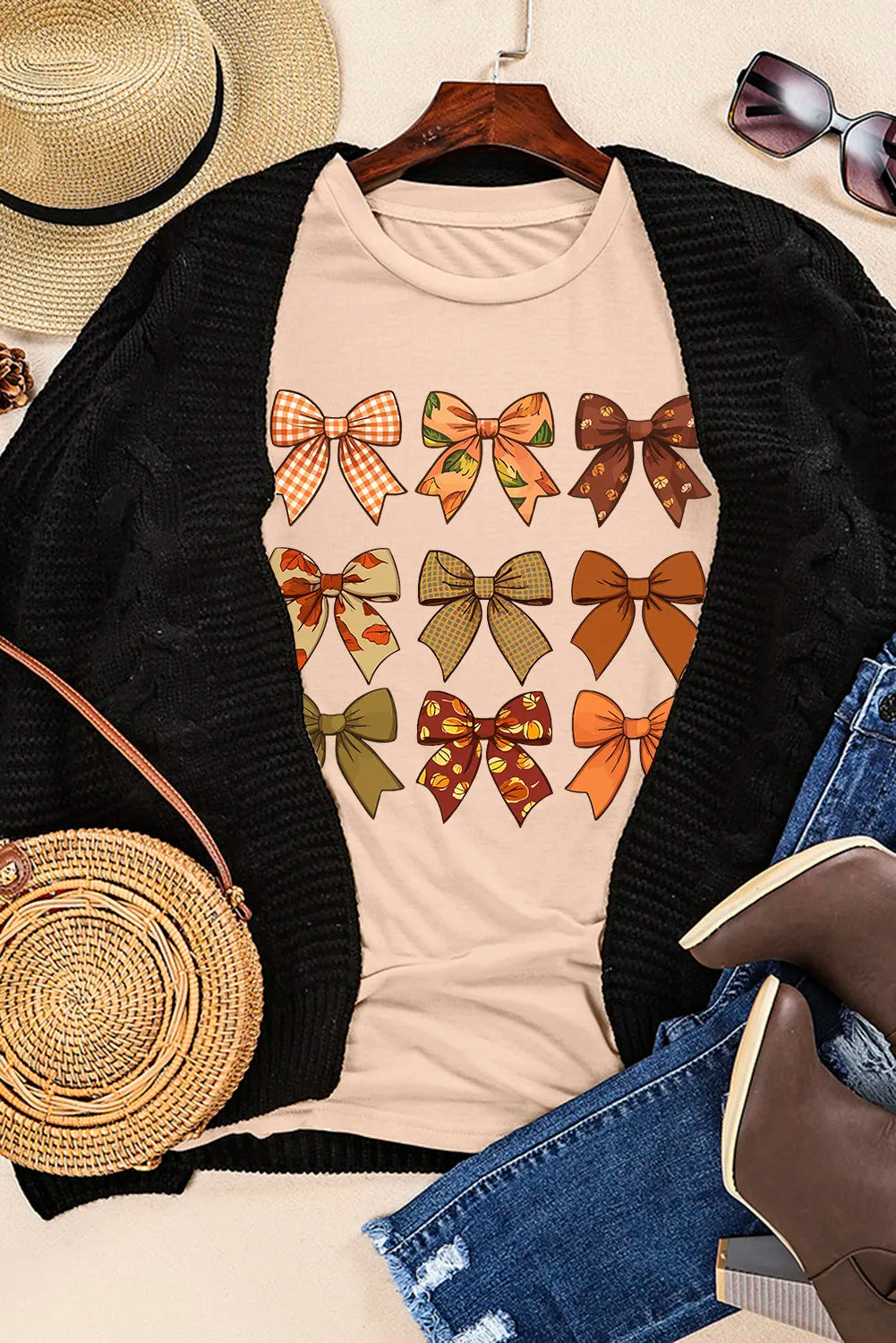 Styled outfit with bow graphic T-shirt, jeans, and accessories.