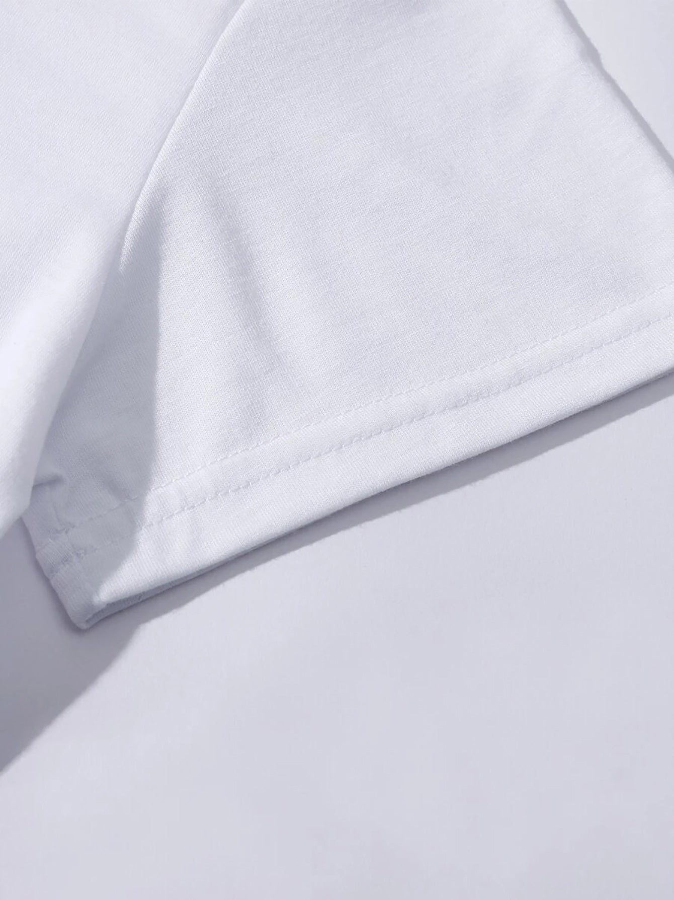 Close-up of white LUCKY t-shirt sleeve detail