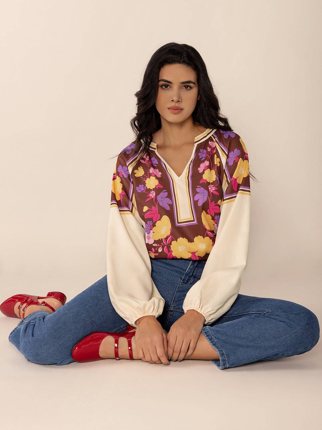 Model seated in floral printed notched blouse