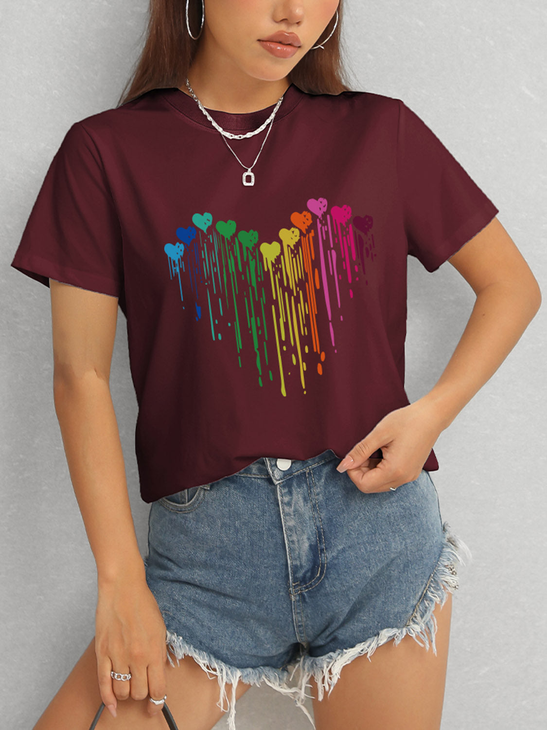Maroon t-shirt with rainbow heart design and short sleeves