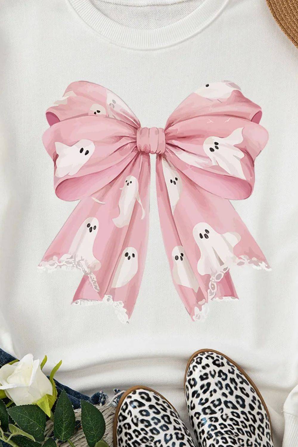 Close-up of pink bow and ghost design on sweatshirt