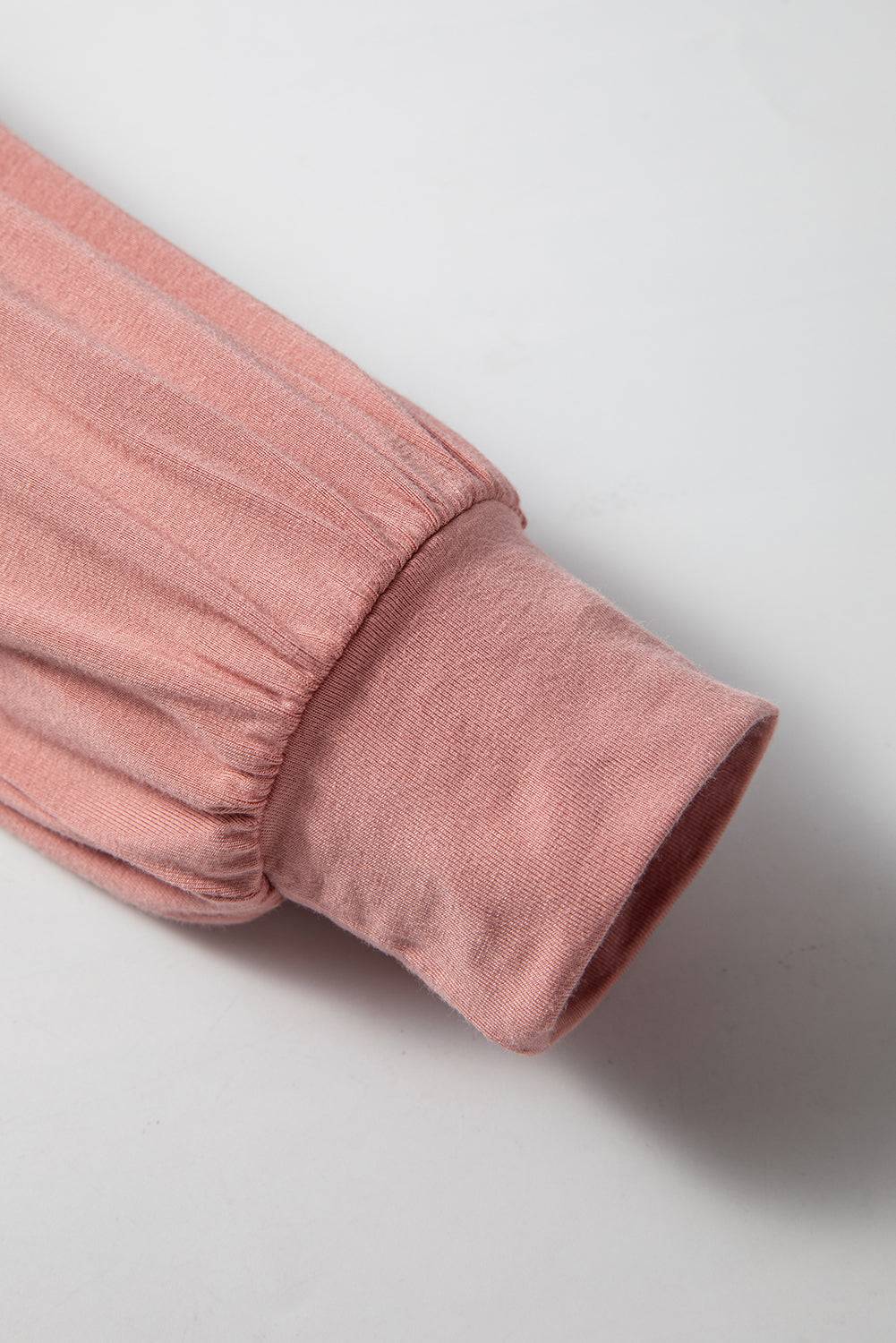Sleeve detail of pink V-neck bodysuit