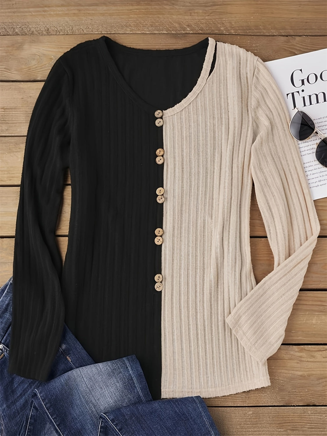 Decorative button contrast T-shirt laid flat with jeans.