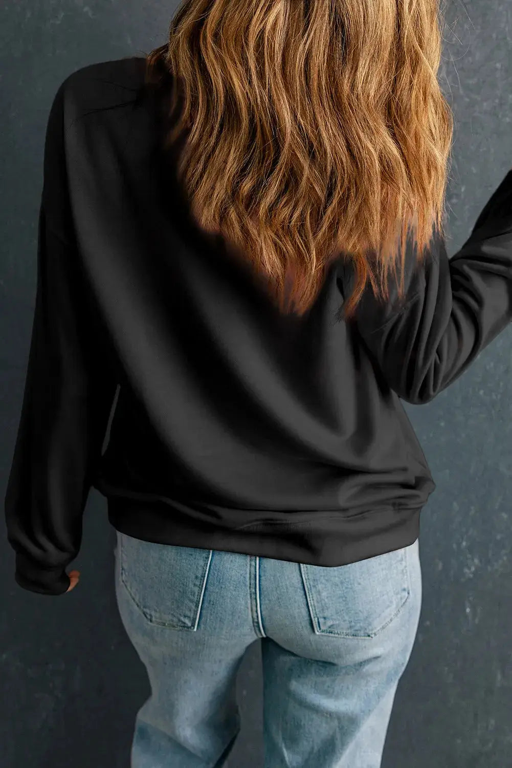 Back view of black long sleeve sweatshirt.