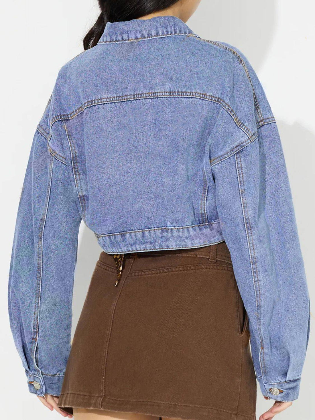 Back view of cropped denim top with dropped shoulders.