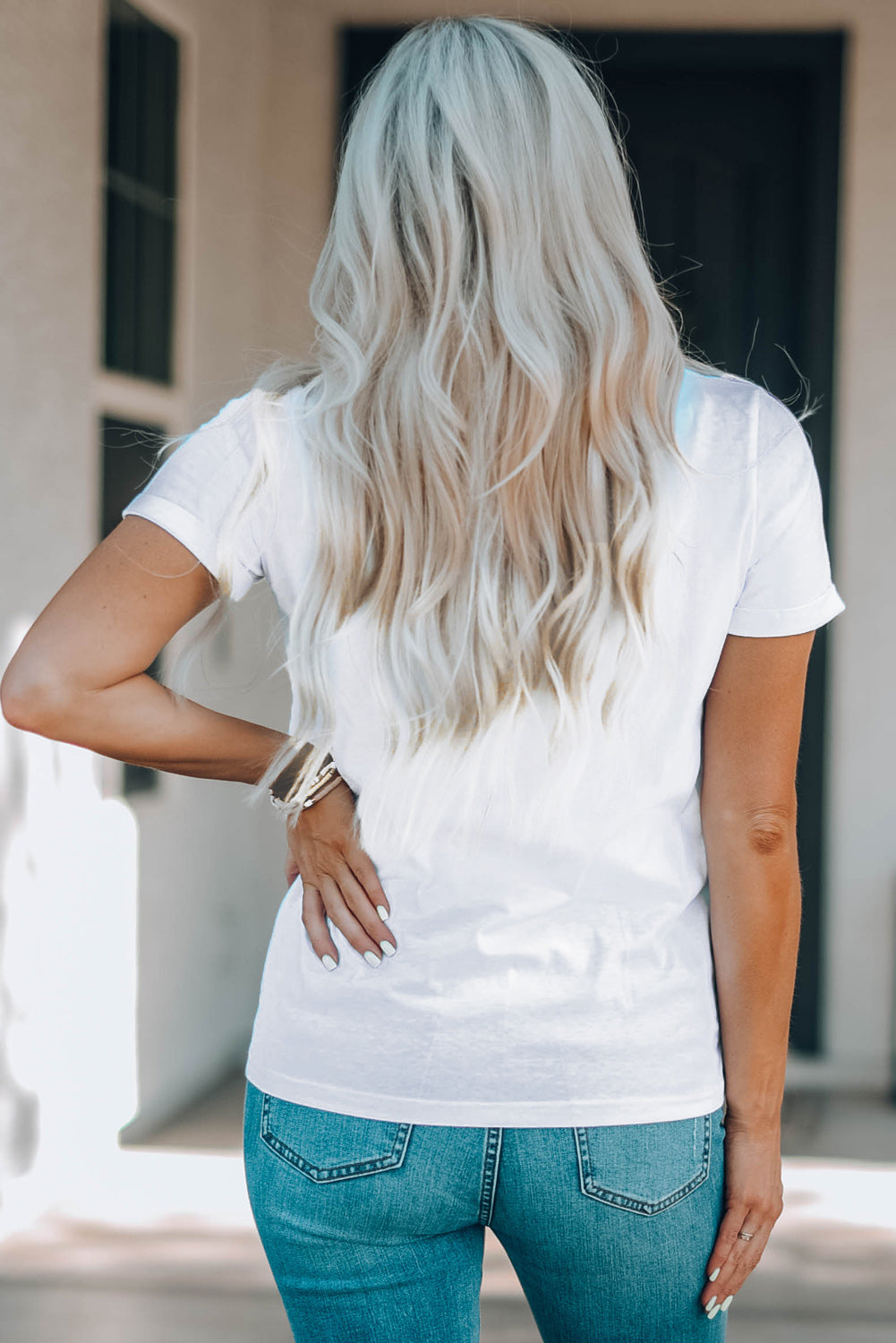 Back view of plain white T-shirt worn by model.