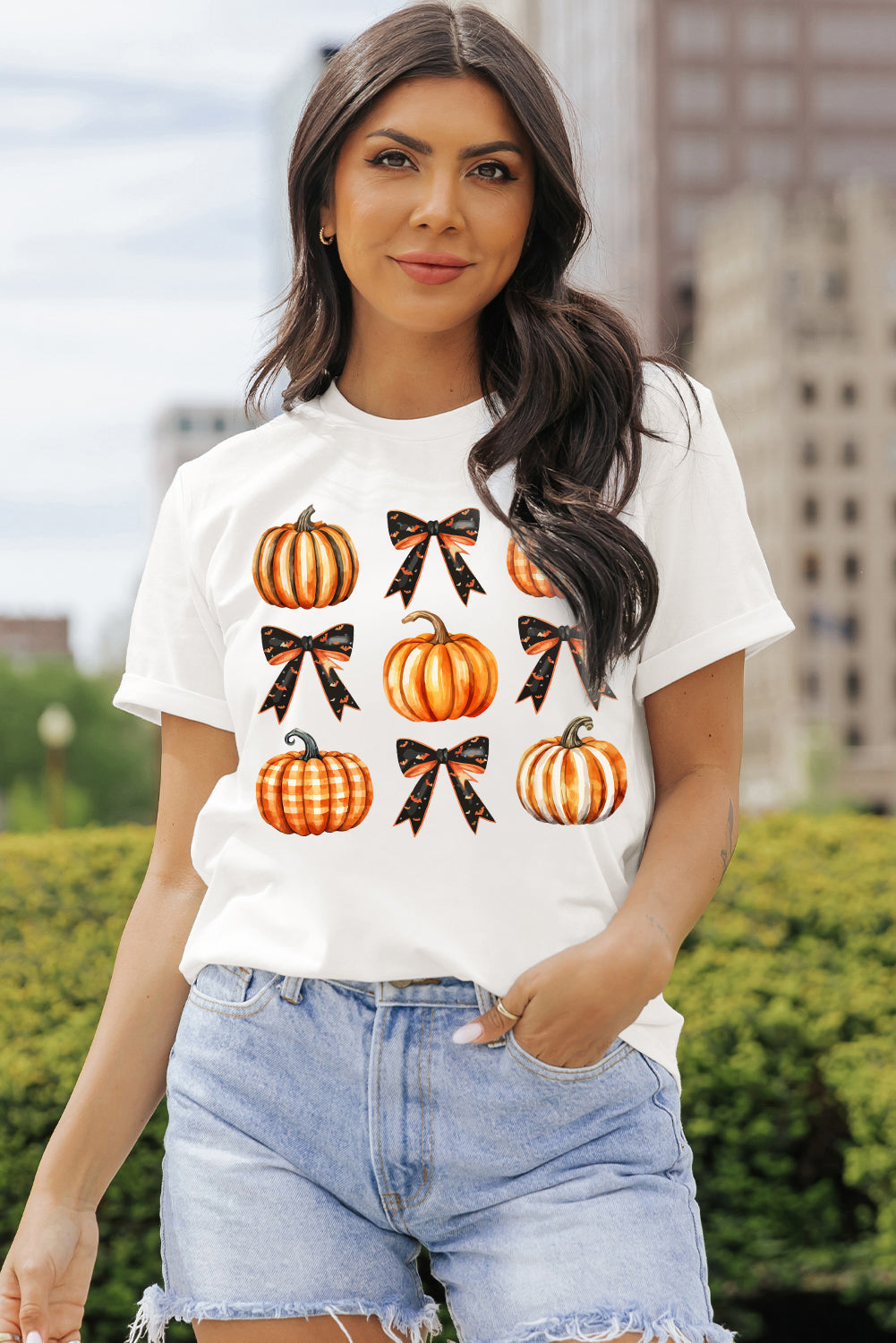 Model wearing pumpkin design T-shirt with denim shorts.
