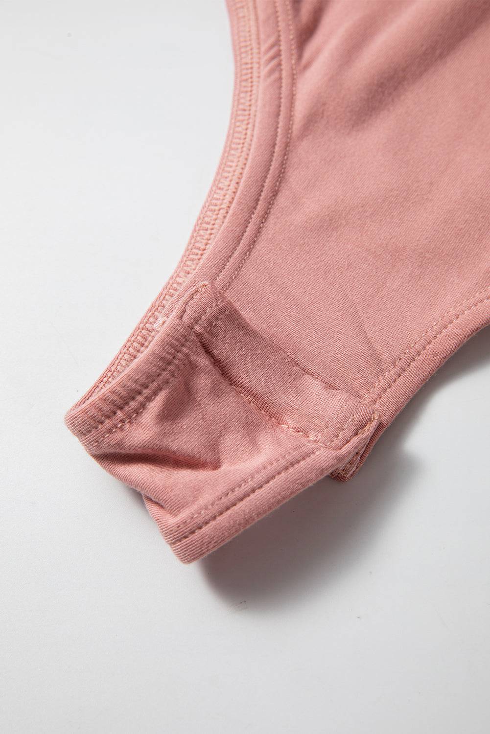 Snap closure detail on pink bodysuit
