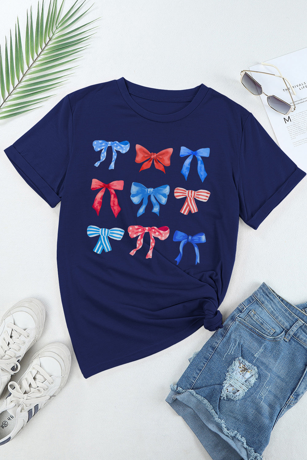 Flat lay of bow graphic T-shirt with jeans and sneakers