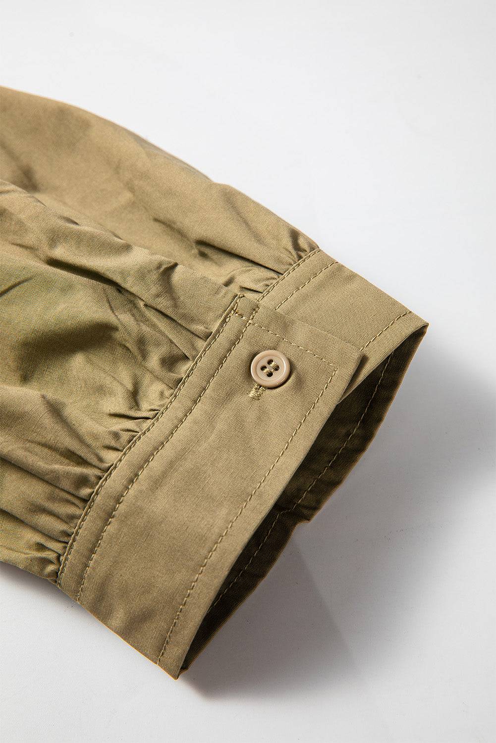 Detail of sleeve with button on mini dress