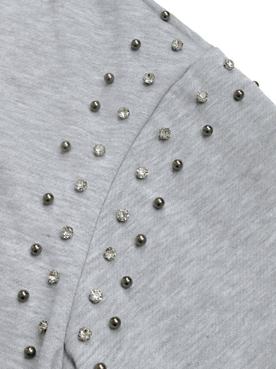 Close-up of rhinestone details on gray hoodie