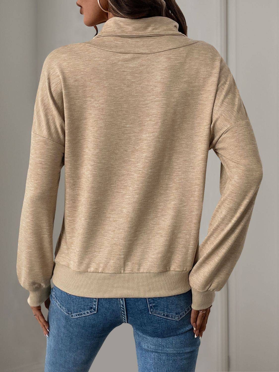 Back view of beige long sleeve mock neck sweatshirt.