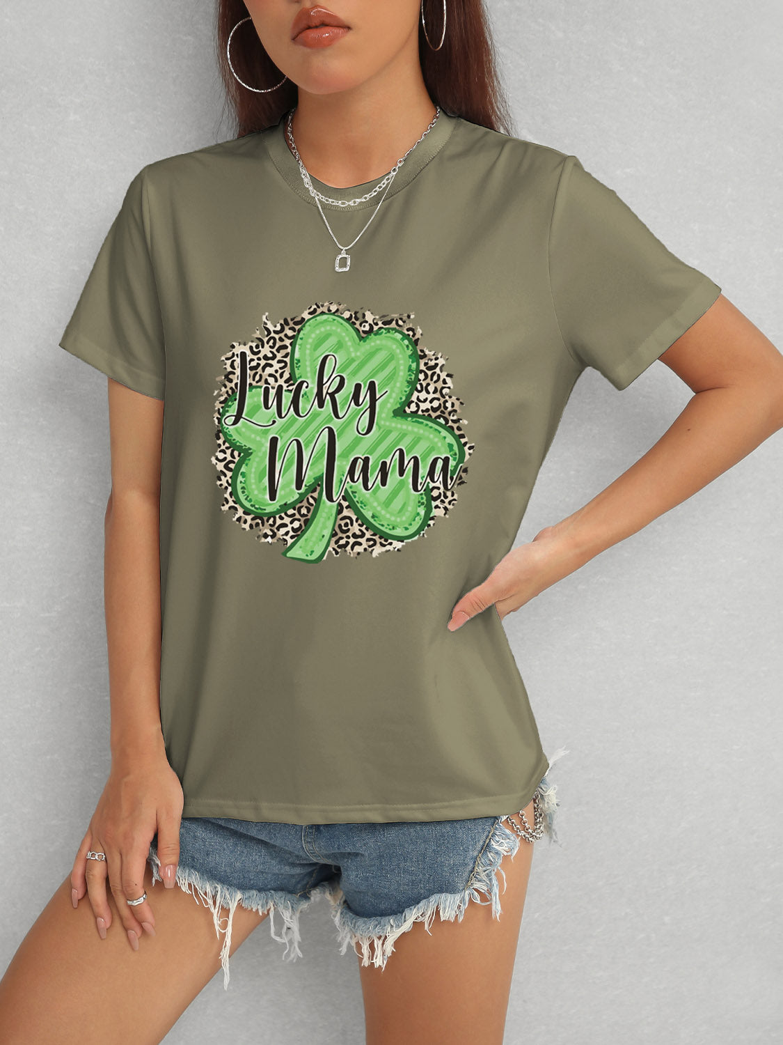Model in olive green Lucky Mama t-shirt and denim shorts