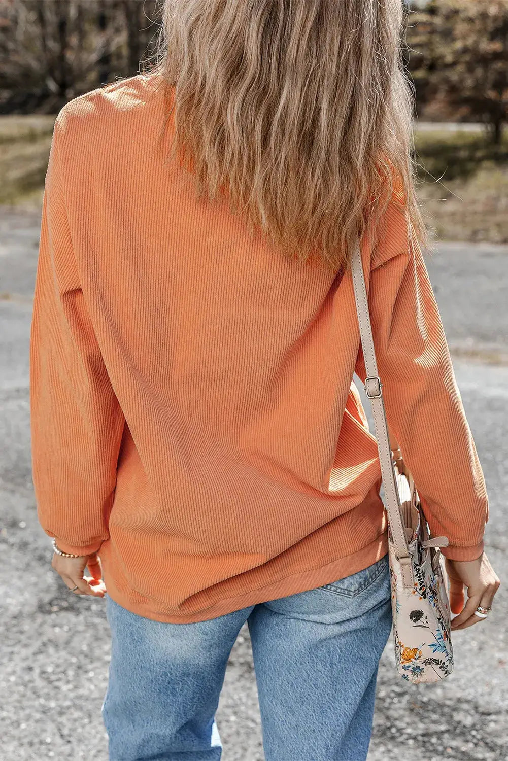 Back view of THANKFUL orange sweatshirt with floral bag