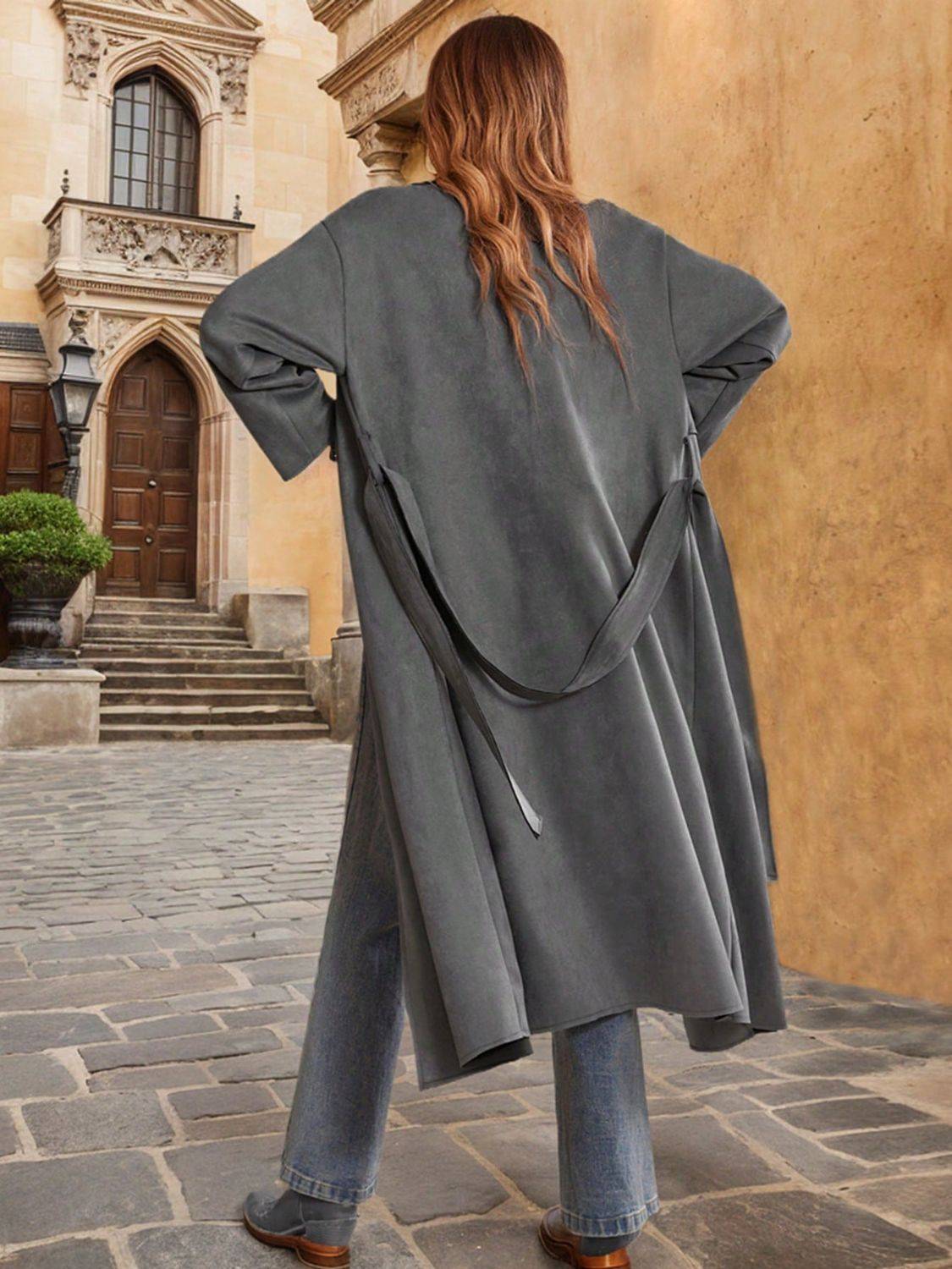 Back view of tie waist long sleeve coat with jeans