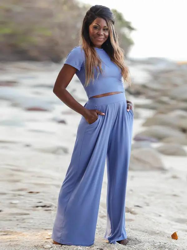 Model wearing blue two-piece set on beach