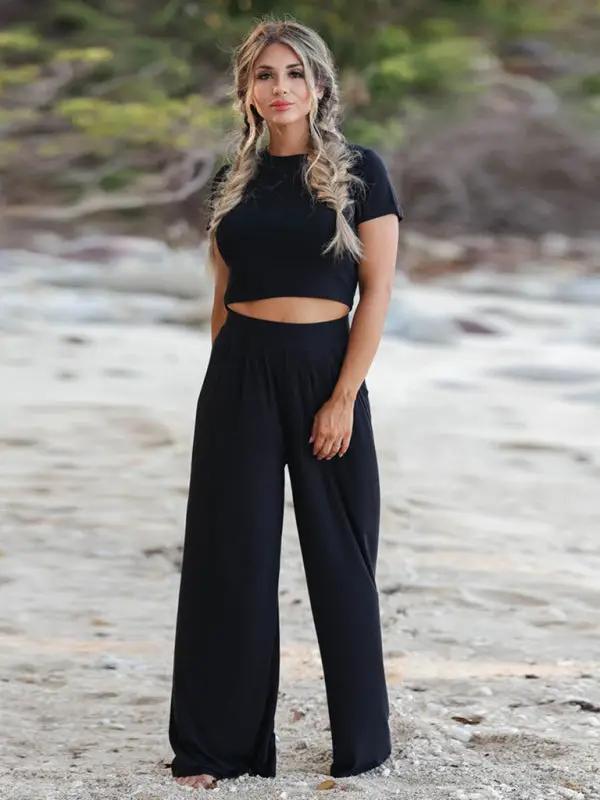 Model wearing black two-piece set on beach