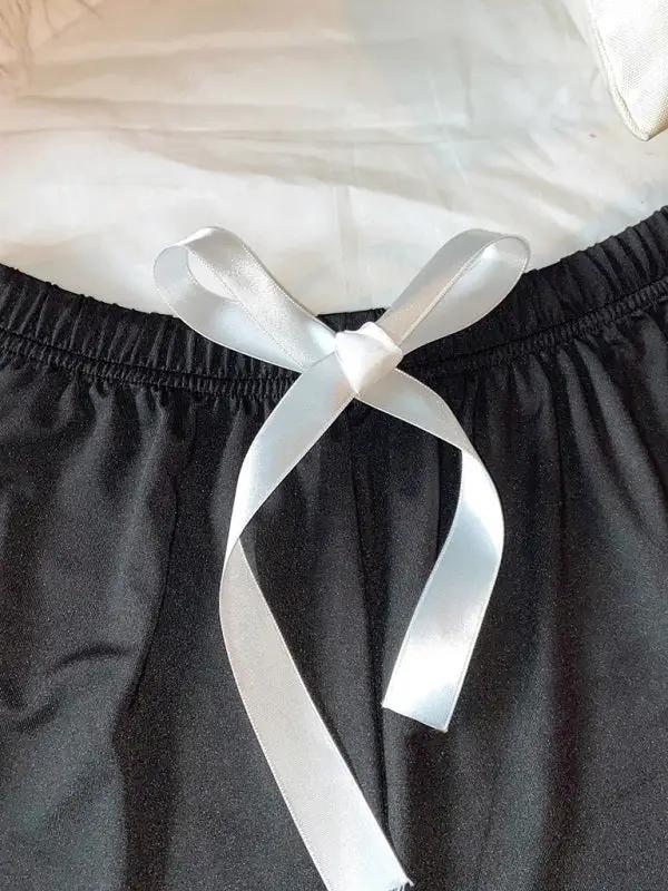 White ribbon tie on black pajama shorts waistband