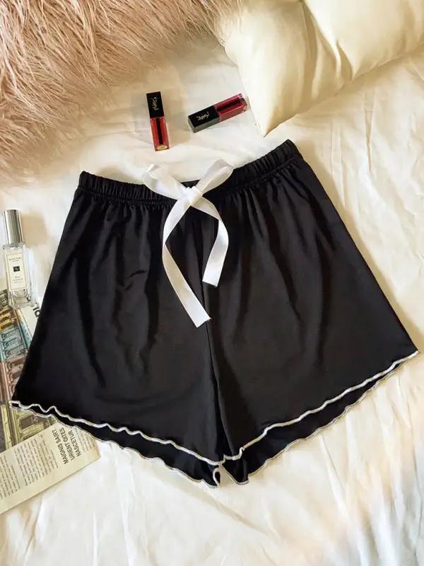 Black pajama shorts styled with accessories on bed