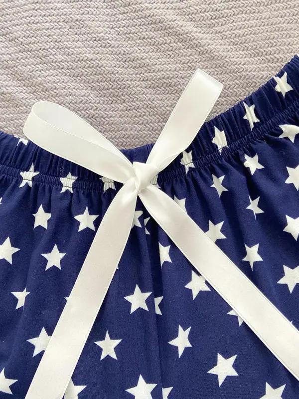 Detail of white ribbon on star-patterned pajama shorts