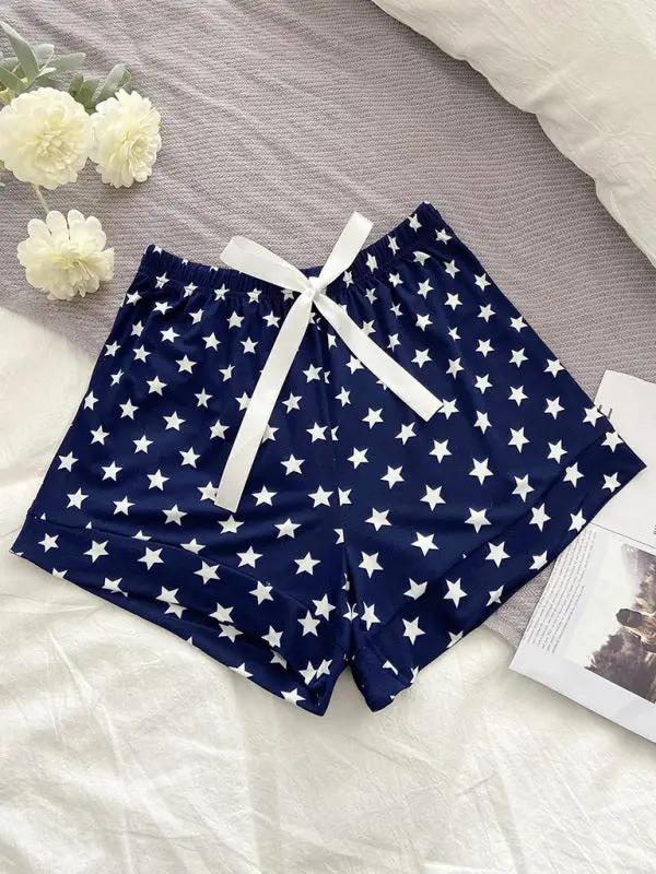 Star-patterned navy pajama shorts on bed with flowers