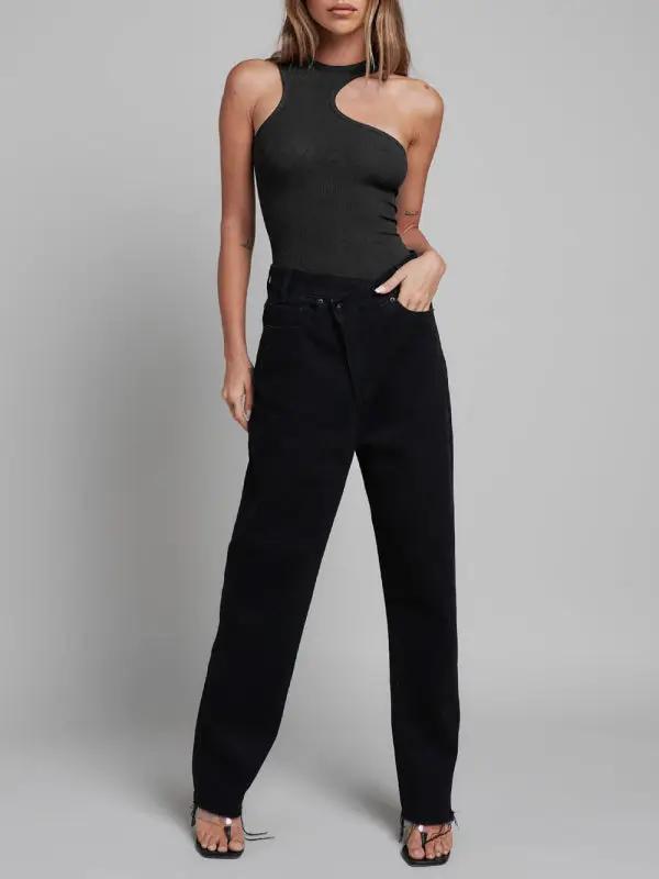 Black sleeveless jumpsuit paired with black pants