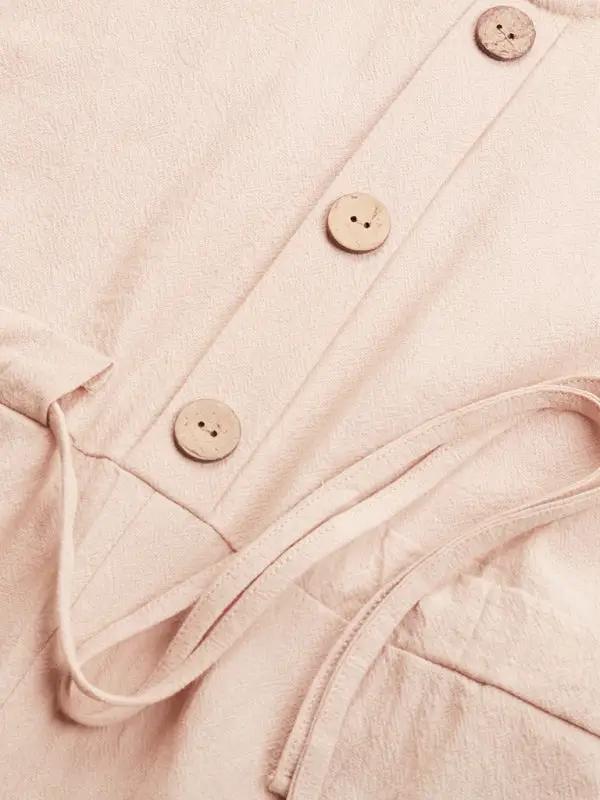 Close-up of beige romper buttons and tie