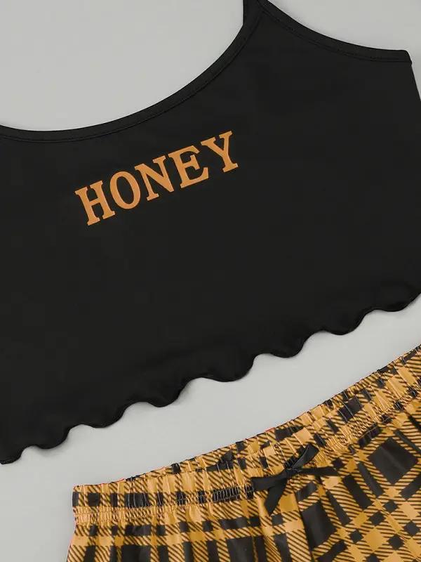 Close-up of black camisole with yellow &