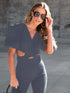 Model in dark denim jumpsuit with puff sleeves and crossover waist