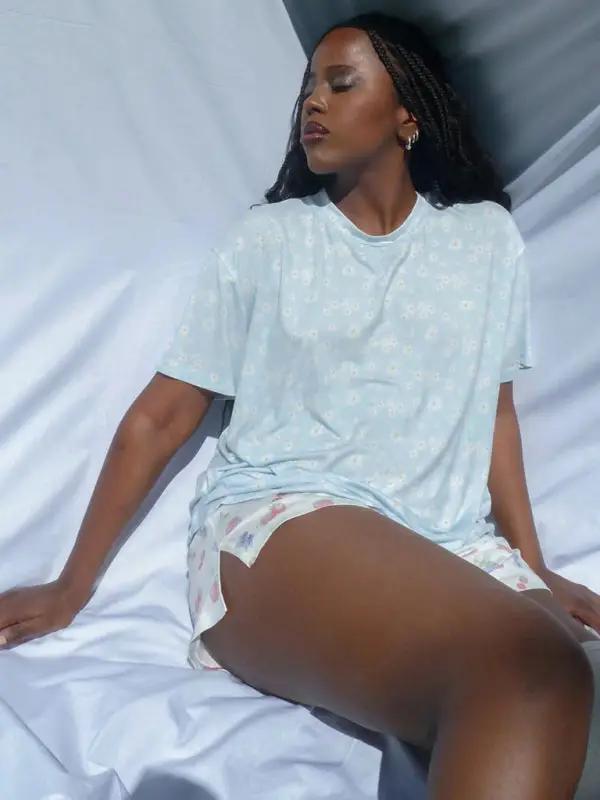 Woman lounging in blue printed pajama set