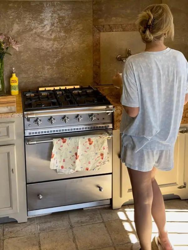 Back view of woman in kitchen wearing pajamas